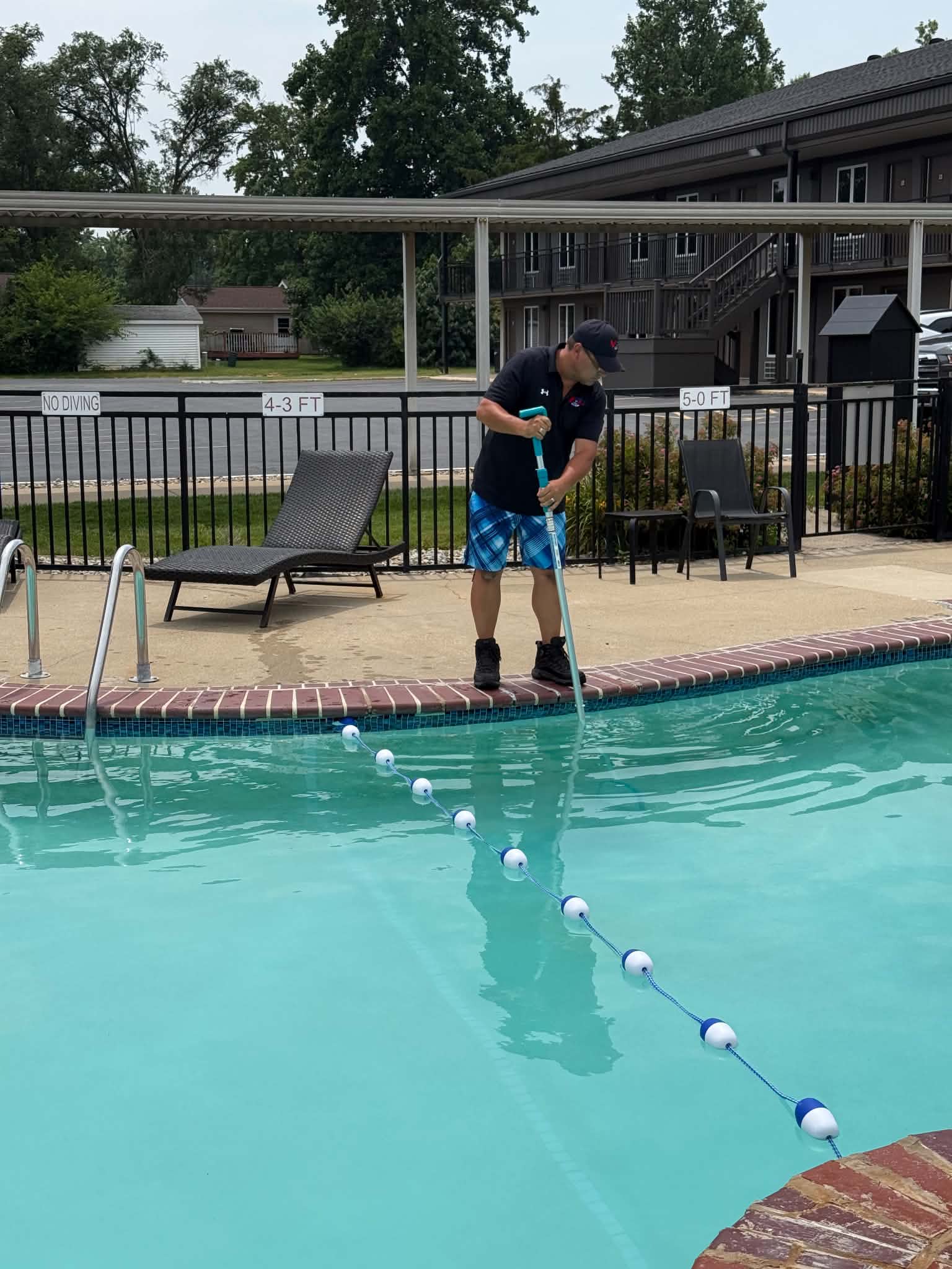 An American Spas team member cleaning an outdoor hotel pool